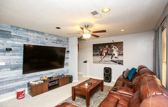 living area with an accent wall, visible vents, recessed lighting, carpet, and a ceiling fan