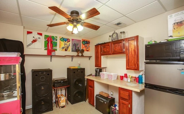 kitchen with visible vents, a paneled ceiling, light countertops, freestanding refrigerator, and a ceiling fan