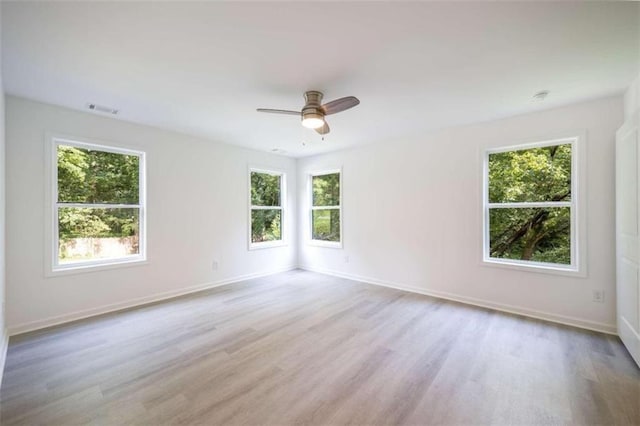 empty room with light hardwood / wood-style flooring and plenty of natural light