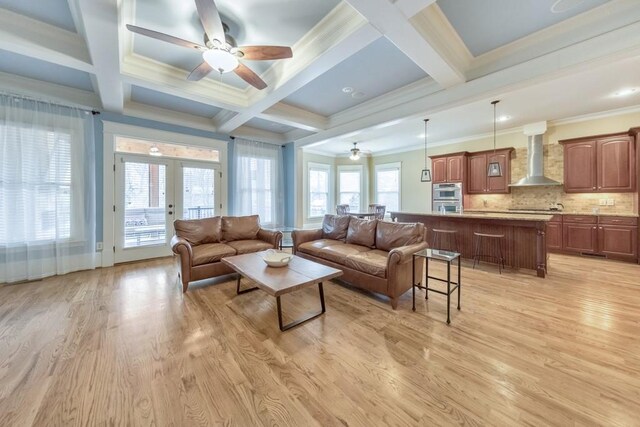 living room featuring french doors, light hardwood / wood-style floors, crown molding, and beam ceiling