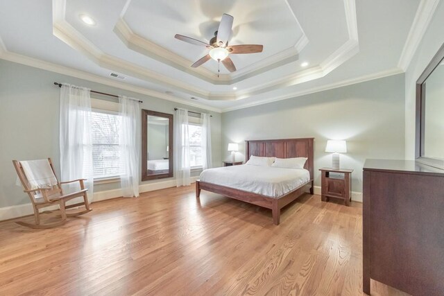 bedroom with a raised ceiling, ceiling fan, crown molding, and light hardwood / wood-style floors