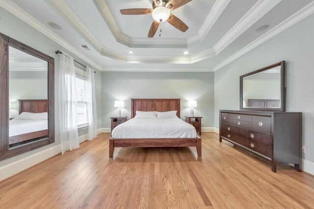 bedroom with a raised ceiling, ceiling fan, crown molding, and light hardwood / wood-style flooring