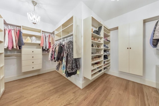 walk in closet featuring a chandelier and light hardwood / wood-style floors