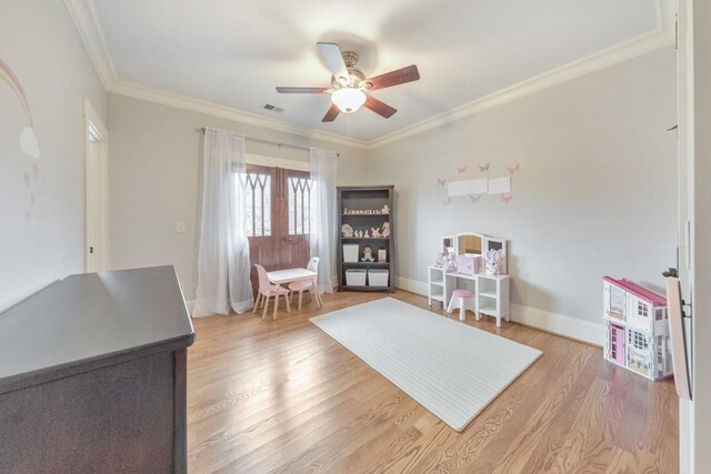 sitting room featuring wood-type flooring, ceiling fan, and ornamental molding