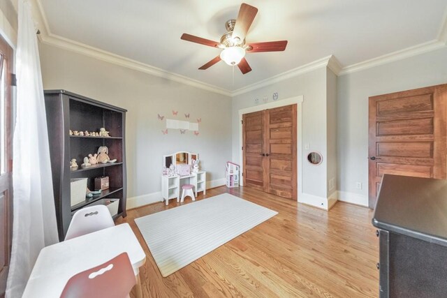 sitting room featuring ceiling fan, light wood-type flooring, and ornamental molding