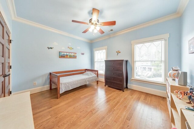 bedroom featuring ceiling fan, crown molding, and light wood-type flooring