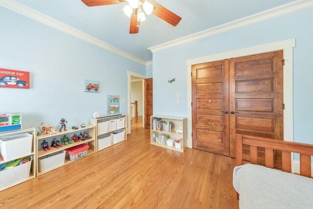 bedroom with light hardwood / wood-style floors, ceiling fan, and crown molding