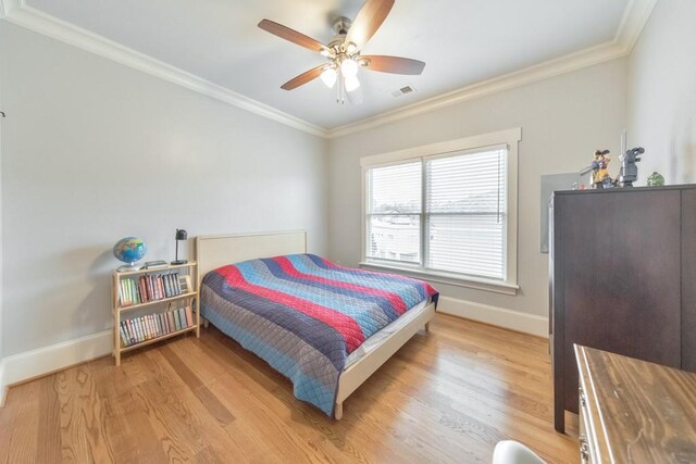 bedroom with ceiling fan, light wood-type flooring, and ornamental molding