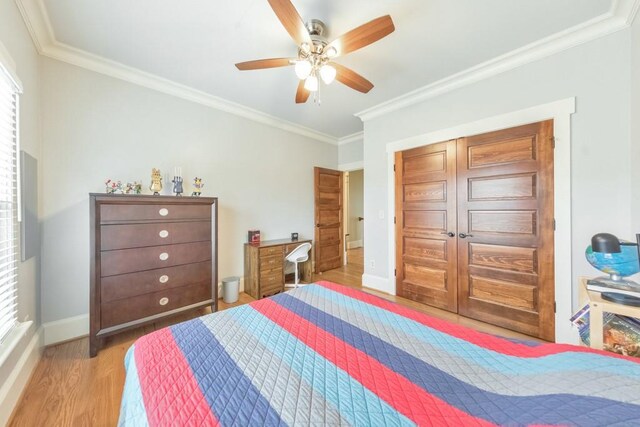 bedroom featuring ceiling fan, light wood-type flooring, ornamental molding, and multiple windows