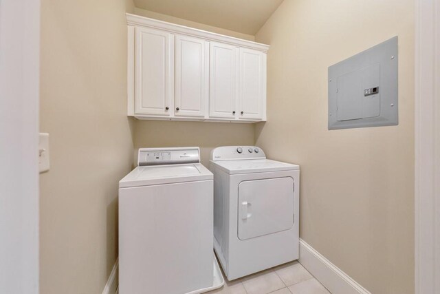 clothes washing area with washer and dryer, light tile patterned floors, electric panel, and cabinets