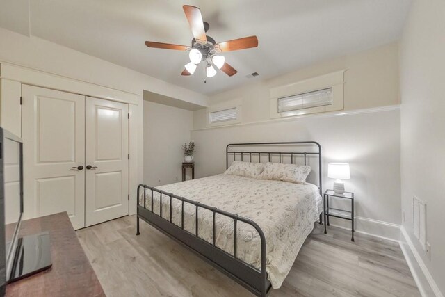 bedroom featuring light wood-type flooring, a closet, and ceiling fan