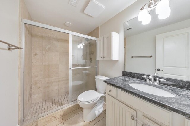 bathroom featuring tile patterned floors, vanity, toilet, and walk in shower