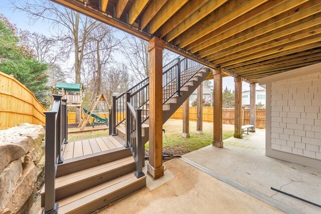 deck featuring a playground and a patio area