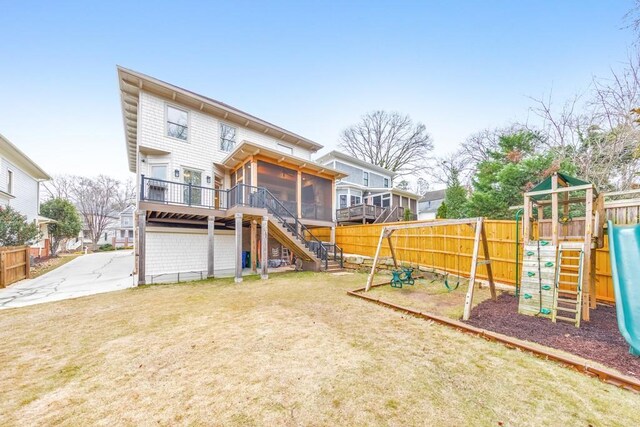 back of property featuring a yard, a playground, and a sunroom