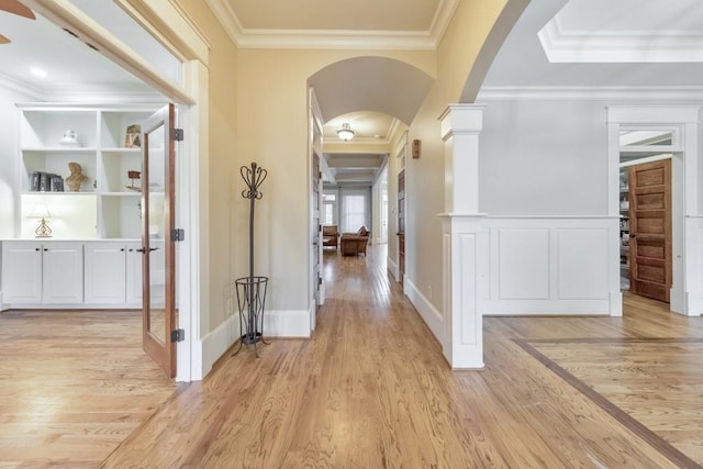 corridor with light hardwood / wood-style flooring and crown molding