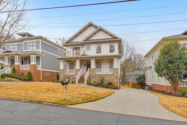 view of front of house featuring a front lawn, cooling unit, and a porch