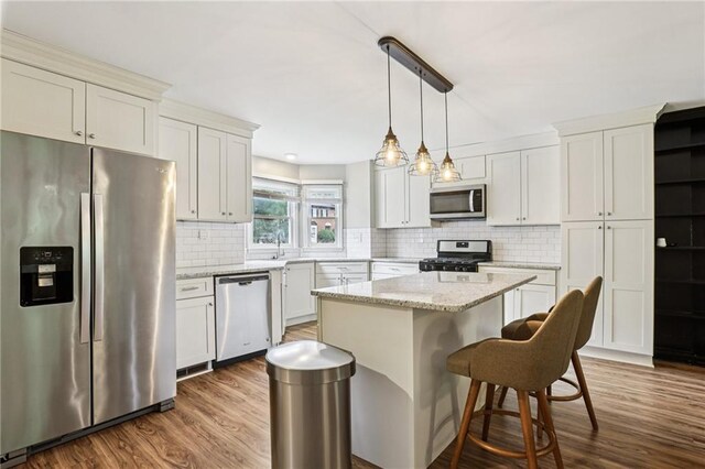 208 Hembree Park Ter, Roswell, GA 30076 - kitchen with stainless steel appliances, dark wood finished floors, decorative backsplash, and a kitchen island