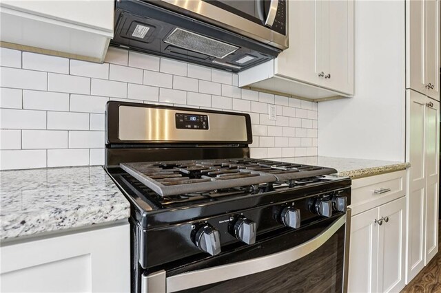 208 Hembree Park Ter, Roswell, GA 30076 - kitchen featuring appliances with stainless steel finishes, white cabinets, tasteful backsplash, and light stone counters