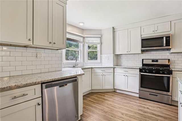 208 Hembree Park Ter, Roswell, GA 30076 - kitchen with appliances with stainless steel finishes, decorative backsplash, and light stone counters