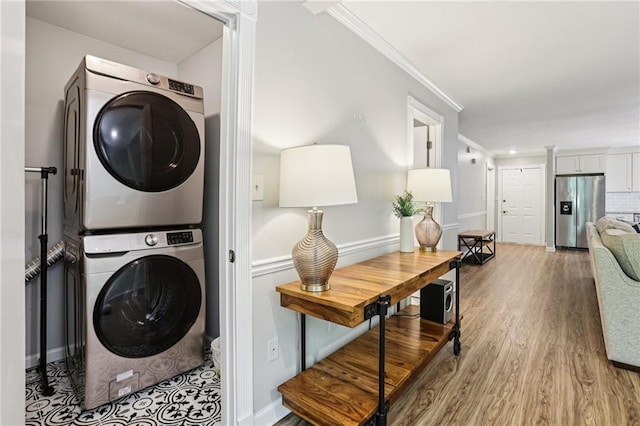 208 Hembree Park Ter, Roswell, GA 30076 - laundry room featuring stacked washer / dryer, ornamental molding, and wood finished floors
