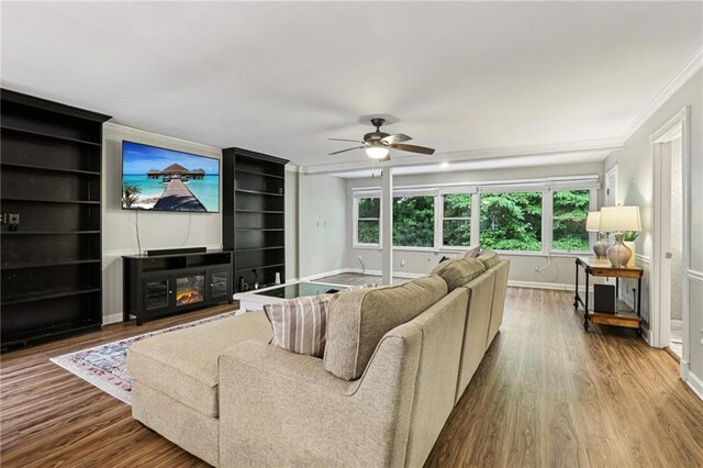 208 Hembree Park Ter, Roswell, GA 30076 - living room featuring wood finished floors, ornamental molding, ceiling fan, a glass covered fireplace, and built in features