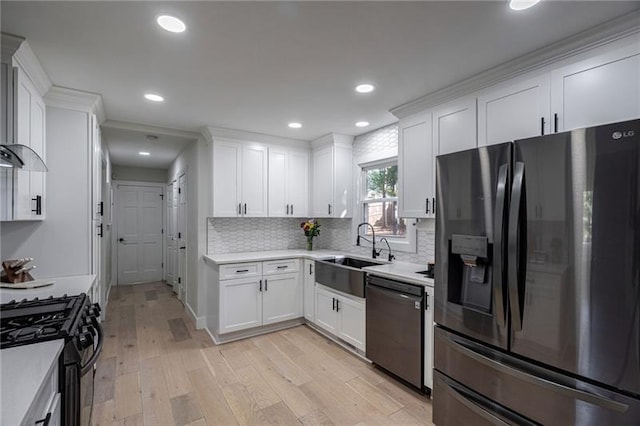 kitchen featuring sink, white cabinets, light wood-type flooring, and appliances with stainless steel finishes