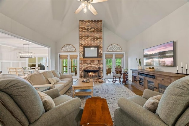 726 Swilling Rd, Eastanollee, GA 30538 - living area with high vaulted ceiling, a fireplace, wood finished floors, a ceiling fan, and a chandelier