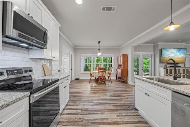 726 Swilling Rd, Eastanollee, GA 30538 - kitchen with appliances with stainless steel finishes, a sink, crown molding, white cabinetry, and light wood-style floors