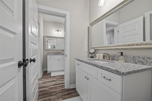 726 Swilling Rd, Eastanollee, GA 30538 - bathroom featuring wood finished floors, two vanities, and baseboards