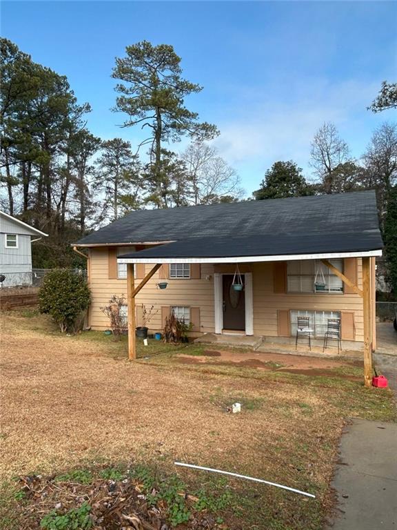 view of front of property with a front lawn and a carport