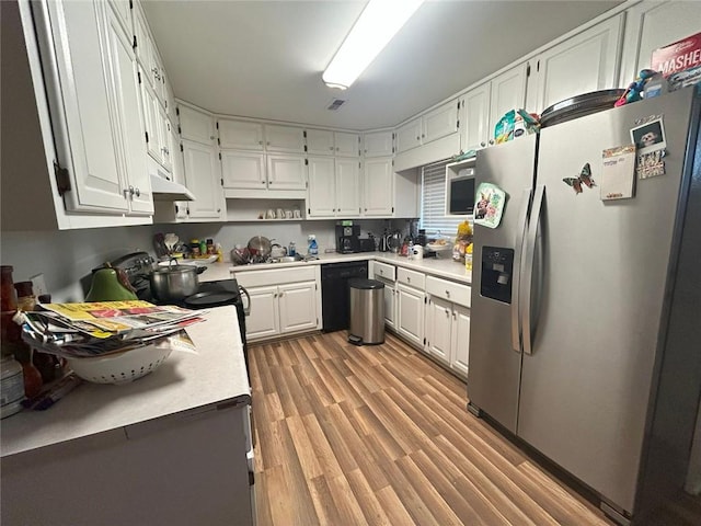 kitchen featuring stainless steel range with electric cooktop, dark hardwood / wood-style flooring, dishwasher, white cabinets, and sink