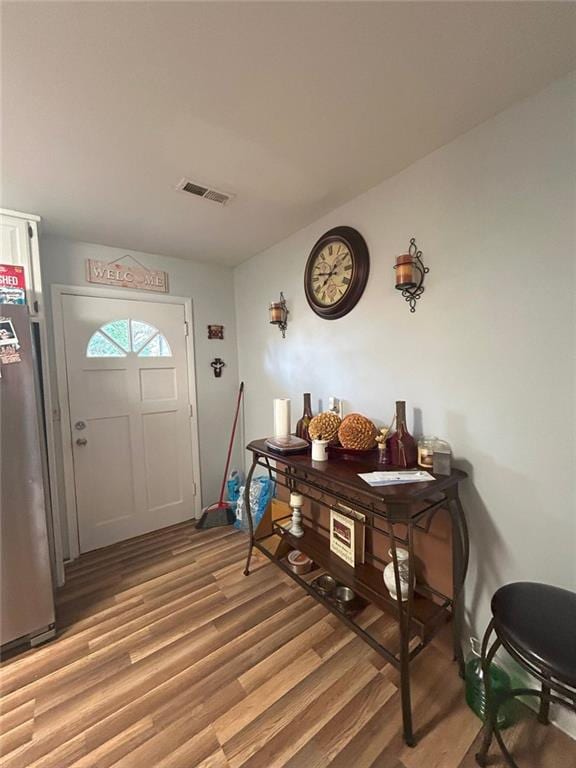 kitchen featuring white cabinets, stainless steel refrigerator with ice dispenser, and light hardwood / wood-style flooring