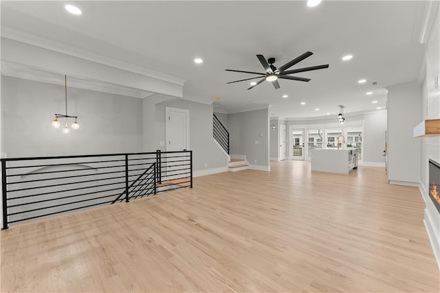 3932 Boston Common St, Suwanee, GA 30024 - unfurnished living room with ornamental molding, recessed lighting, ceiling fan, light wood-type flooring, and a glass covered fireplace