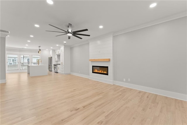 3932 Boston Common St, Suwanee, GA 30024 - unfurnished living room with crown molding, recessed lighting, a fireplace, light wood-style flooring, and baseboards