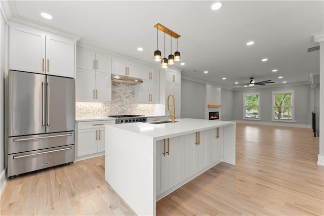 3932 Boston Common St, Suwanee, GA 30024 - kitchen with high end refrigerator, a sink, a ceiling fan, light wood-style flooring, and crown molding