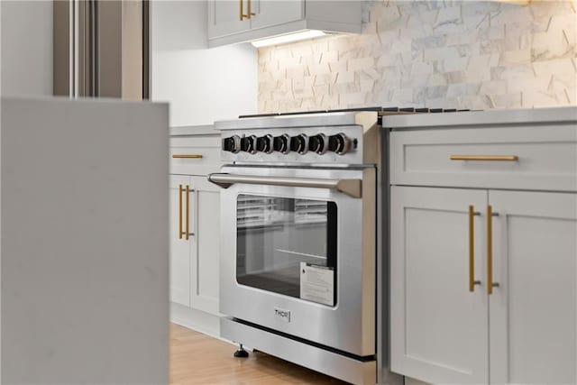3932 Boston Common St, Suwanee, GA 30024 - kitchen featuring backsplash, light wood finished floors, and stainless steel stove