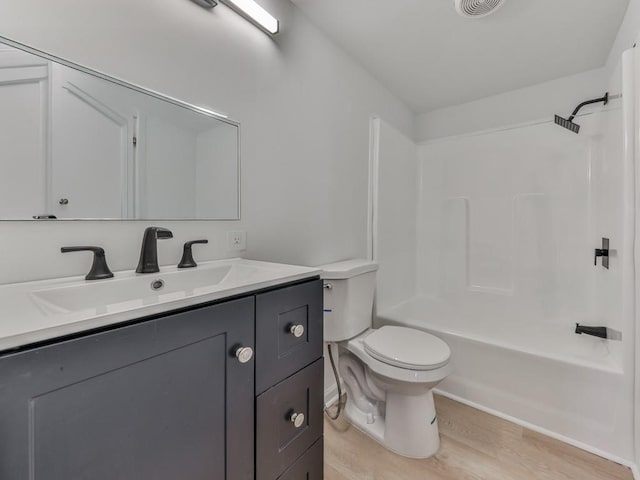 full bathroom featuring vanity, hardwood / wood-style floors, shower / tub combination, and toilet