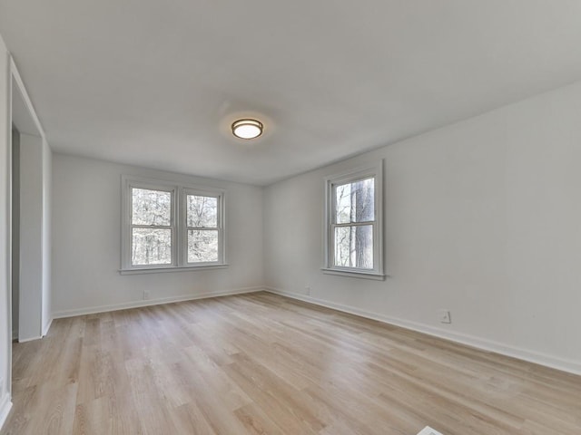 spare room featuring plenty of natural light and light hardwood / wood-style floors