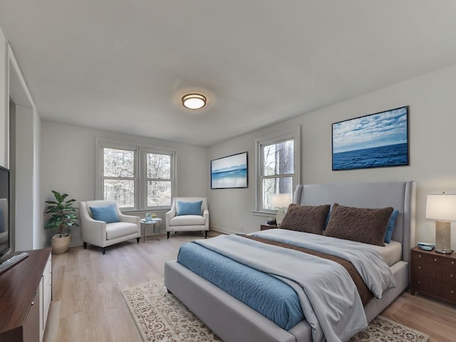 bedroom with light hardwood / wood-style floors and multiple windows