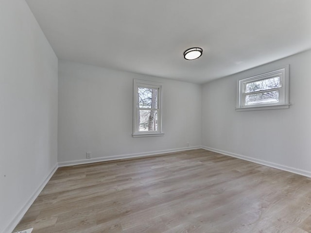 empty room featuring plenty of natural light and light hardwood / wood-style floors