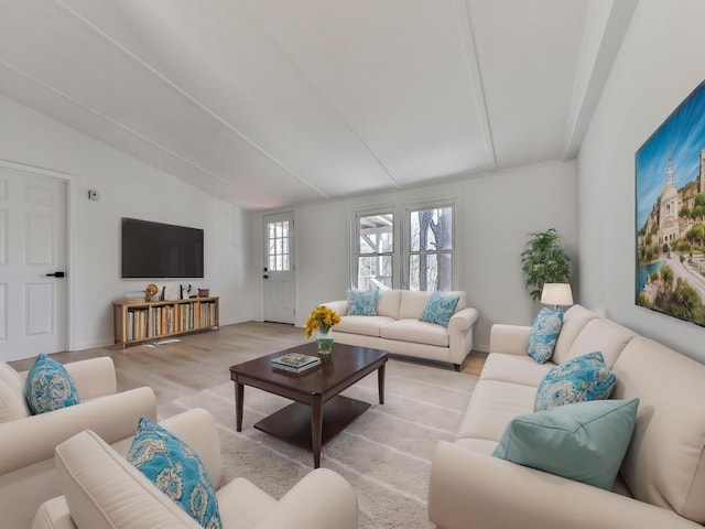 living room featuring lofted ceiling and light hardwood / wood-style floors