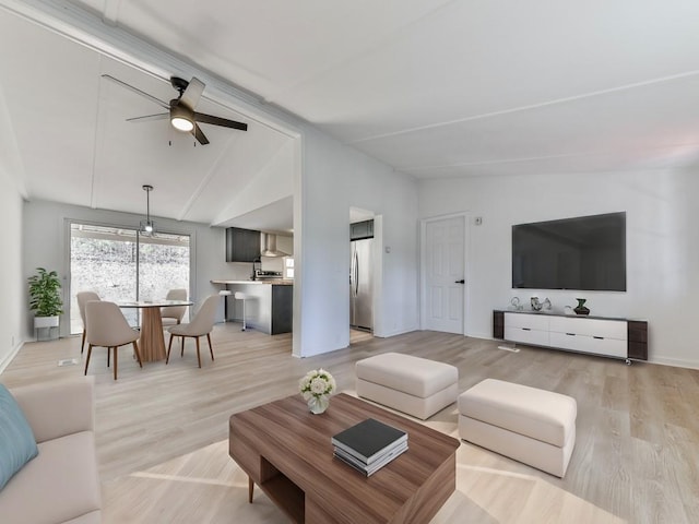 living room featuring light hardwood / wood-style flooring, vaulted ceiling, and ceiling fan