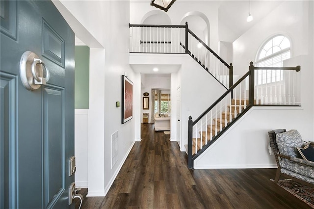 foyer entrance with dark hardwood / wood-style flooring and a high ceiling