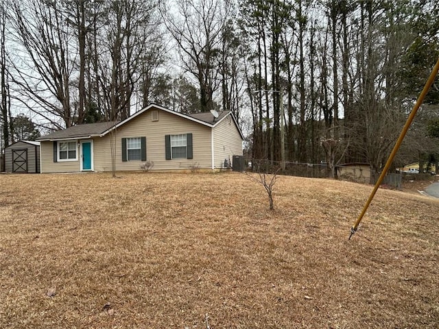 view of home's exterior featuring a yard, central air condition unit, and a storage unit