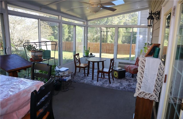 sunroom with ceiling fan, a wealth of natural light, and vaulted ceiling