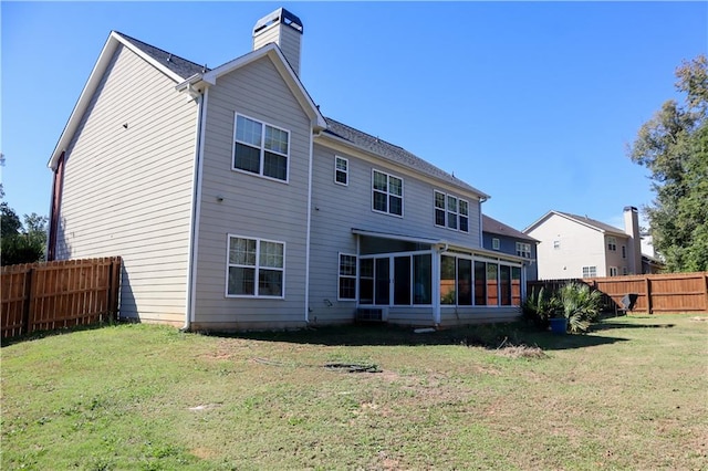 back of house featuring a sunroom and a yard