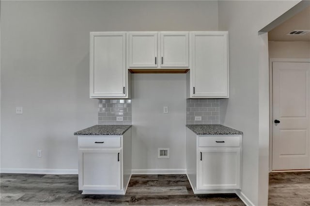 kitchen with dark stone countertops, dark hardwood / wood-style floors, and white cabinets