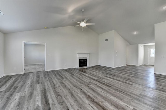 unfurnished living room with ceiling fan, lofted ceiling, wood-type flooring, and a fireplace