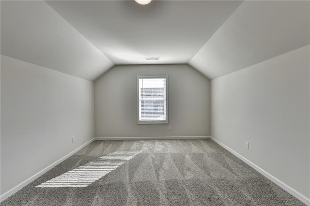 bonus room with vaulted ceiling and light colored carpet