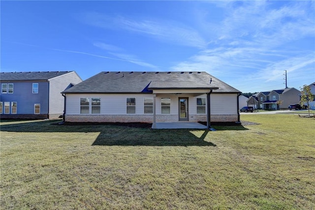 back of house with a lawn and a patio